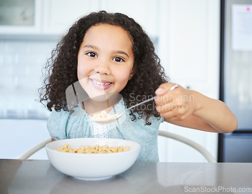 Image of Would you like some. an adorable little girl having breakfast at the kitchen table.