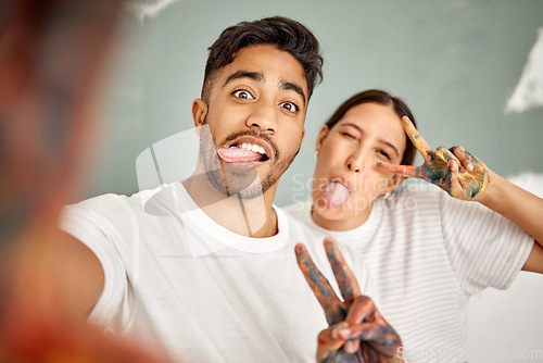 Image of Doing the renovations yourself is fun. a young couple taking a selfie while painting together at home.