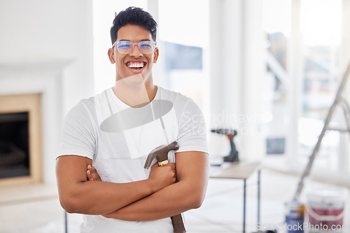 Image of Give a man the right tools and hell do anything. a man holding a hammer while busy renovating a house.