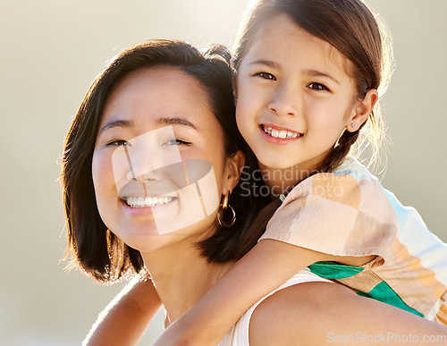 Image of Growing up to be just like mommy. Cropped portrait of an attractive young woman piggybacking her daughter on the beach.