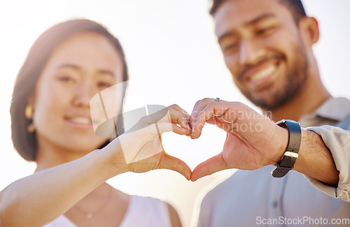 Image of Love is in the air. an affectionate young couple making a heart shape with their hands on the beach.