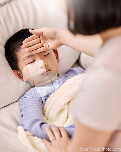 Image of I think I should let him sleep in. a woman checking her sick childs temperature.