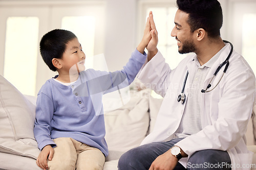 Image of Dont forget to continue eating all your veggies. a male doctor visiting a little boy at home.