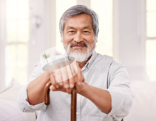 Image of Nothing matters more than having a positive attitude. a senior man sitting at home with a wooden walking stick.