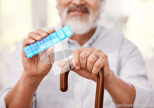 Image of Im a little forgetful when it comes to medication so this helps. a senior man sitting with a walking stick and holding up a weekly pill box.