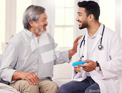Image of Im all about making life easier for my patients. a doctor holding a pill box while talking to a senior patient.