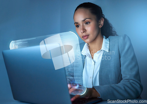 Image of Im the code master. an attractive young businesswoman sitting alone in the office and using her laptop.