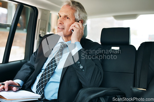 Image of He moves to where the business is. a mature businessman using a mobile phone in the back seat of a car.