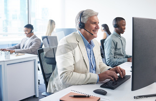 Image of We have an amazing offer for you. a mature businessman using a headset and computer in a modern office.