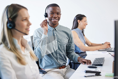 Image of Thanks for calling the technical support team. Portrait of a young businessman using a headset and computer in a modern office.