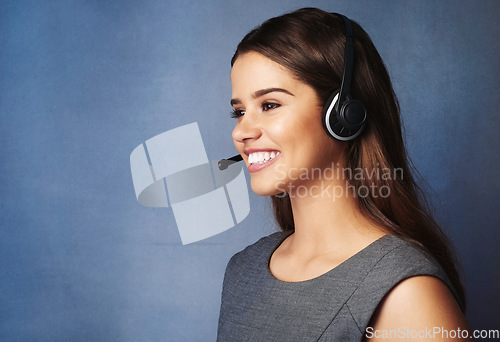 Image of Shes got superior communication skills. Studio shot of a professional young woman wearing a headset against a gray background.