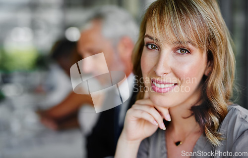 Image of Dreams seldom materialize on their own. Portrait of a businesswoman sitting in a boardroom meeting with colleagues blurred in the background.