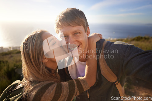 Image of He comes up with the best ideas. Portrait of a handsome young man getting a kiss from his girlfriend while out on a hike.