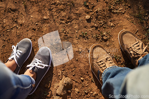 Image of Get some dirt on your shoes. Cropped high angle shot of two people standing on a dirt track.