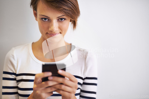 Image of Ready... steady... text. A cropped portrait of a beautiful young woman using a smartphone.