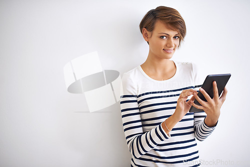 Image of Its so easy to use. A cropped portrait of a beautiful young woman holding a tablet.