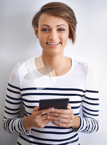 Image of I love new gadgets. A cropped portrait of a beautiful young woman holding a tablet.