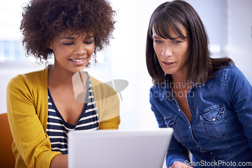 Image of Sharing the possibilities. two coworkers looking at a digital tablet.