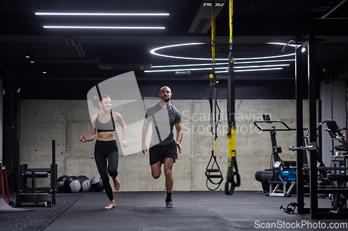 Image of A fit couple in a modern gym, engaging in running exercises and showcasing their athletic prowess with a dynamic start.