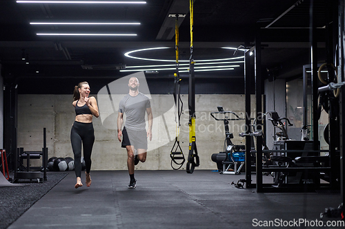 Image of A fit couple in a modern gym, engaging in running exercises and showcasing their athletic prowess with a dynamic start.