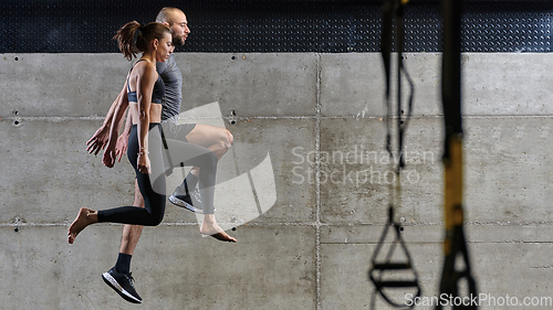 Image of A fit couple exercising various types of jumps in a modern gym, demonstrating their physical fitness, strength, and athletic performance