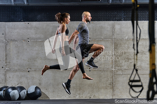 Image of A fit couple exercising various types of jumps in a modern gym, demonstrating their physical fitness, strength, and athletic performance