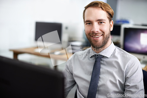 Image of Happy to do business with you. A handsome businessman working at his desk.