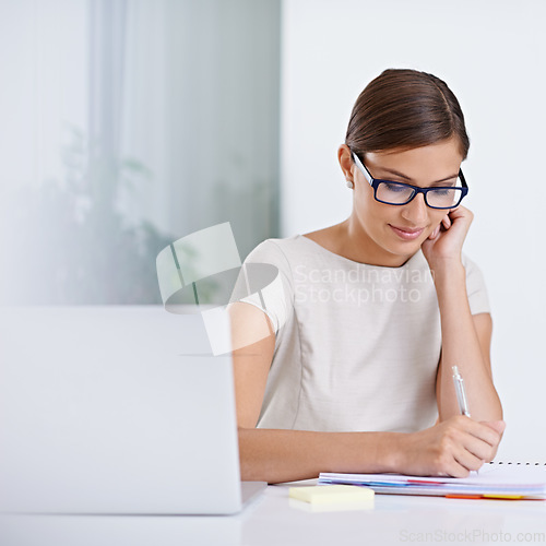 Image of Climbing the ladder with some hard work. a young business woman working at a desk.