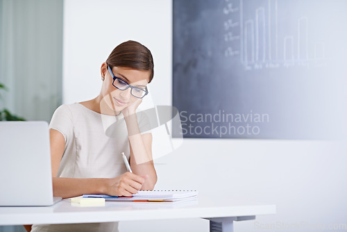 Image of Concentrating hard on completing her work properly. a young business woman working at a desk.