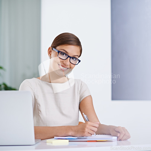 Image of I just need to take a few details down. Portrait of an attractive young business woman working.