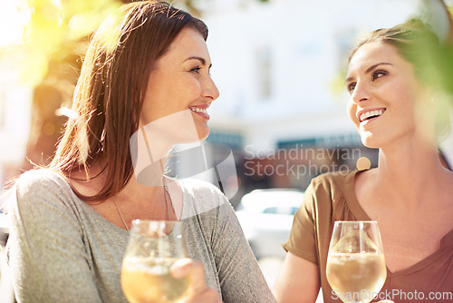 Image of The best wines are the ones we drink with friends. two women enjoying a glass of wine together at a cafe.