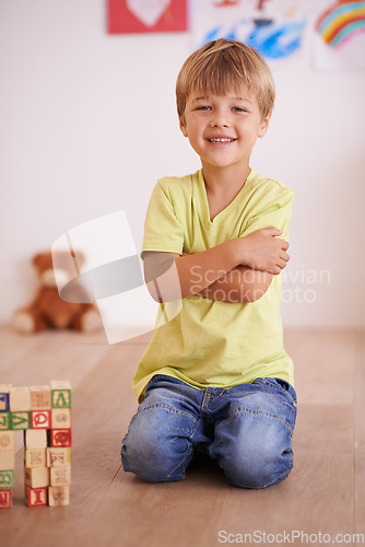 Image of Future civil engineer. A little boy sitting proudly next to a tower he built.