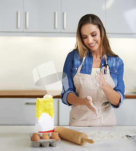 Image of Doughy goodness. a smiling woman at work in her kitchen making dough.