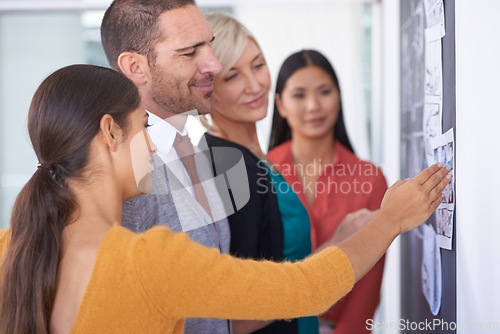 Image of This team always goes above and beyond. A team of businesspeople drawing up a storyboard on a chalkboard in the office.