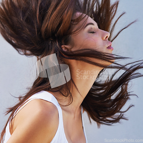 Image of Shake it all about. Closeup shot of a beautiful young woman flinging her brunette hair.