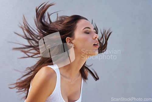 Image of Freedom. a beautiful young woman flinging her brunette hair.