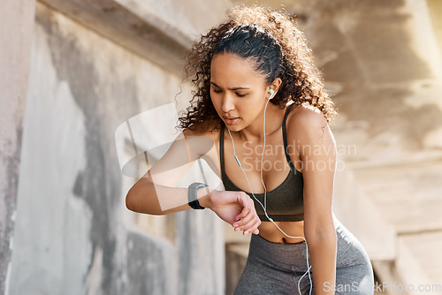 Image of It didnt track anything. an attractive young woman looking contemplative while checking her watch during her outdoor workout.