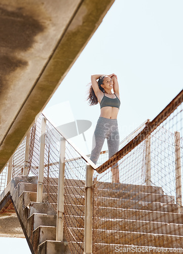 Image of A workout with a view. an attractive young woman standing alone in the city and stretching before her outdoor workout.