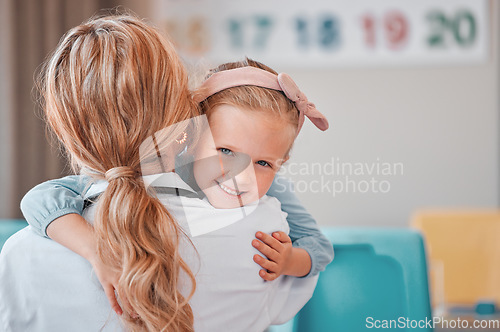 Image of Child psychology at work. Adorable little girl hugging her female therapist. Mental health and wellness are important issues even for kids. Therapy has improved her mood and made her more confident