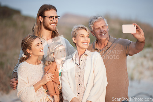 Image of Because you can never have enough family portraits. a senior woman taking a selfie at the beach with her family.