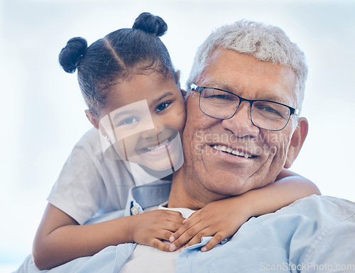 Image of Grandpa and granddaughter smiling while spending quality time together. Loving little girl hugging her grandfather. Senior man with grey hair and glasses bonding with his grandchild