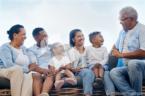 Image of Smiling multi generation mixed race family sitting close together outside in the garden at home. Happy adorable children bonding with their mother, father, grandfather and grandmother in a backyard