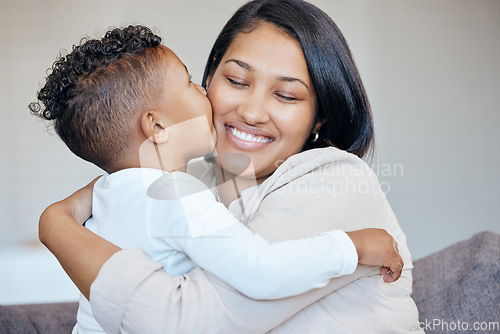 Image of Adorable little boy kissing his mother on the cheek. Happy mixed race mother receiving love and affection from her son. Woman being spoiled on mothers day