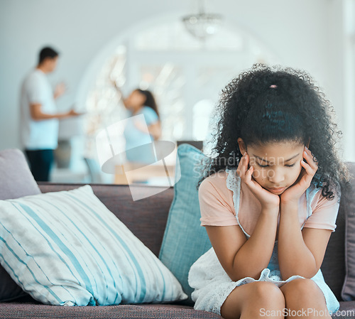 Image of How to make your daughter resentful. a little girl looking sad on a sofa while her parents argue in the background.