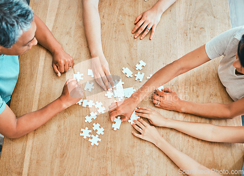 Image of We have all the pieces. a family building a puzzle together at home.