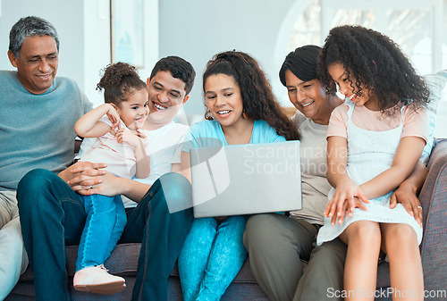 Image of Family never loses its magic. a beautiful family using a laptop while bonding on a sofa at home.