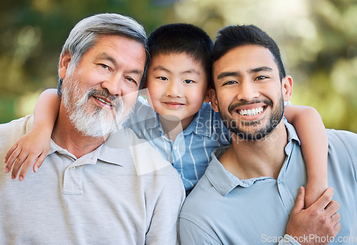 Image of Family sticks together whatever the weather. an adorable little boy spending a fun day in the park with his father and grandfather.