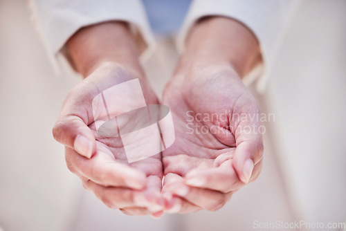 Image of Every cent helps. an unrecognizable person holding out their hands outside.