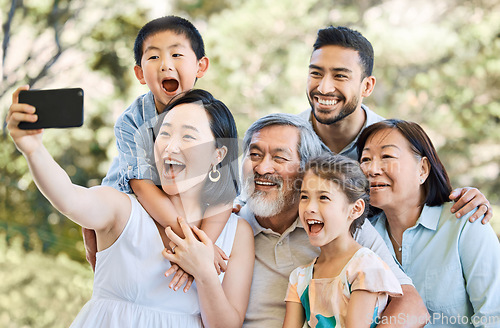 Image of Memories we make with family mean everything. a happy family taking selfies in a garden.