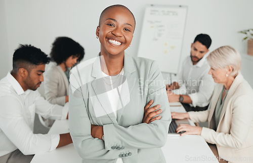 Image of Always busy with meetings. a young businesswoman standing with her arms crossed at work.